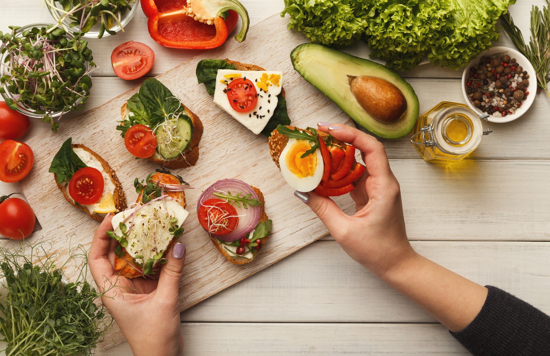 Woman making tasty bruschettas for healthy snack, top view